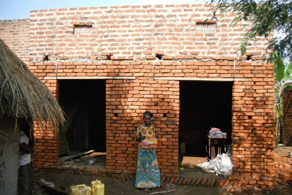 Ugandan Woman with House